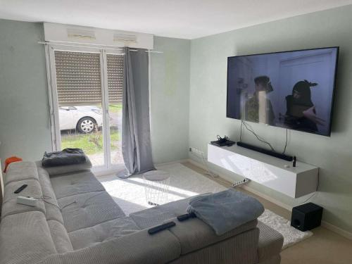 sala de estar con sofá y TV de pantalla plana en Chez Joel Home, en Bergerac