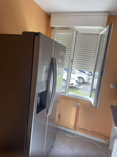 - un réfrigérateur dans une cuisine à côté d'une fenêtre dans l'établissement Chez Joel Home, à Bergerac