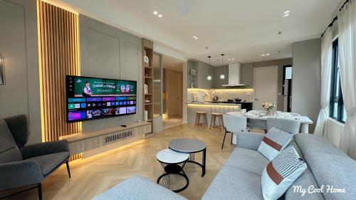 a living room with a couch and a tv and a kitchen at Sunway Onsen Suite Theme Park View Top Floor at Lost World in Tambun