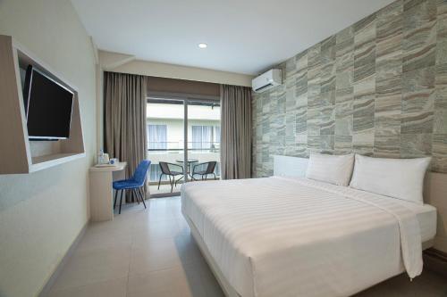 a hotel room with a bed and a tv at Dafam Resort Belitung in Tanjungbinga