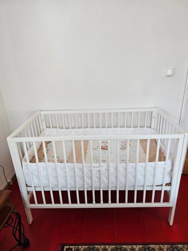 a white crib sitting in a room at Alfapartmány in Krásná Lípa