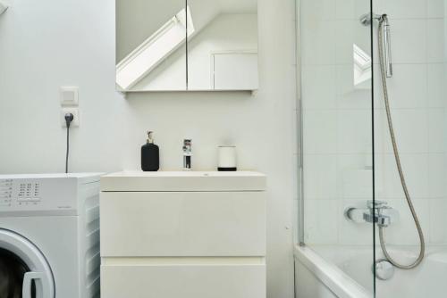 une salle de bain blanche avec un lavabo et une douche dans l'établissement Duplex 2 bedrooms 2 bath, à Lille
