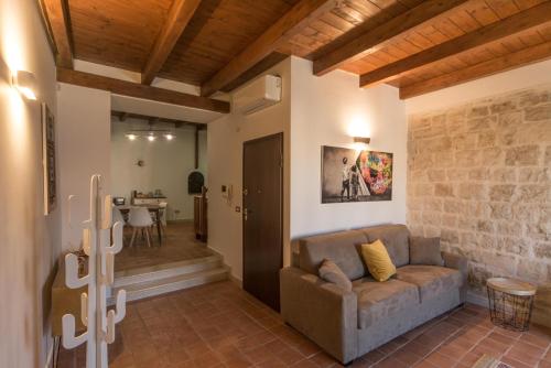 ein Wohnzimmer mit einem Sofa und einem Tisch in der Unterkunft Sui tetti di Trani Harbour suite in Trani