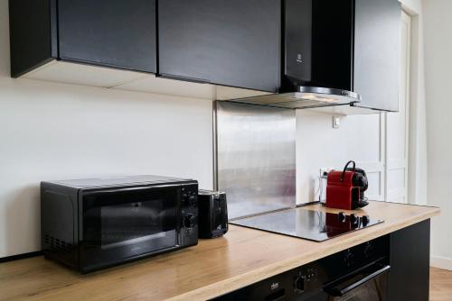 Eine Küche mit einer Mikrowelle auf einer Holzarbeitsplatte in der Unterkunft Duplex 2 bedrooms 2 bath in Lille