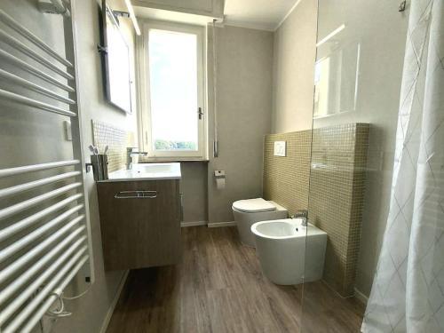 een badkamer met een wastafel, een toilet en een raam bij Sui Canali in Livorno