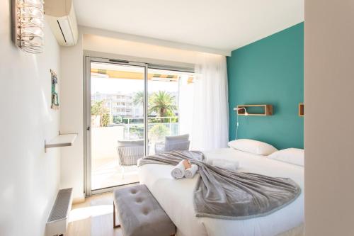 une chambre avec deux lits et une grande fenêtre dans l'établissement C7 - 1 BDR Pointe Croisette 5min Sea - Parking, AC & Terrace, à Cannes