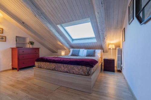 Schlafzimmer im Dachgeschoss mit einem Bett und einem Dachfenster in der Unterkunft Al 19 by Wonderful Italy in Turin