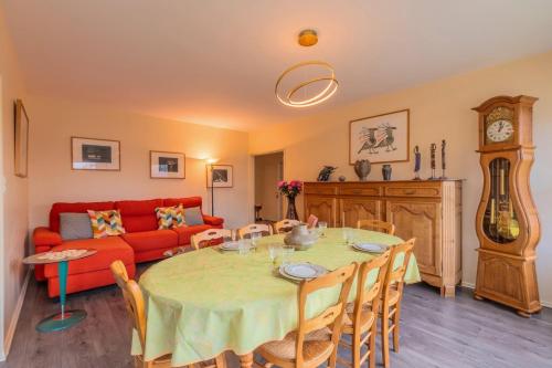 un salon avec une table et un canapé rouge dans l'établissement 2 BR apartment with parking, 5 minutes from Lille, à Marcq-en-Barœul