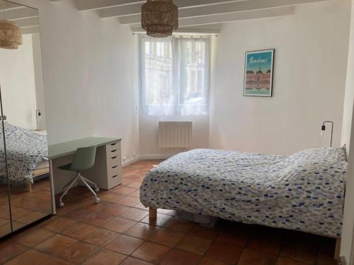 une chambre avec un lit, un bureau et un miroir dans l'établissement Maison de ville St Bruno, à Bordeaux