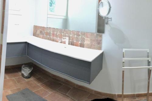 La salle de bains est pourvue d'un grand lavabo et d'un miroir. dans l'établissement Villa avec piscine en Provence, à Sauveterre