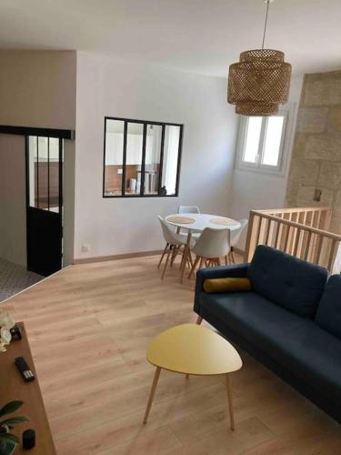 un salon avec un canapé bleu et une table dans l'établissement Maison de ville St Bruno, à Bordeaux