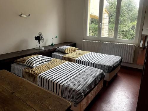 - 2 lits dans une chambre avec 2 fenêtres dans l'établissement Villa avec piscine en Provence, à Sauveterre