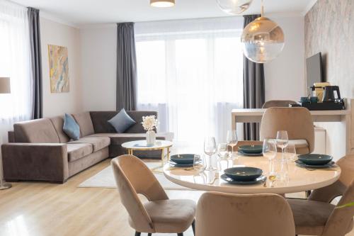 a living room with a table and chairs and a couch at Salt Hill Premium Apartments in Egerszalók