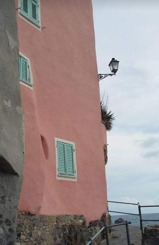 a pink building with two windows and a street light at IL PEPE ROSA di Anna e Silvano in Sarzana