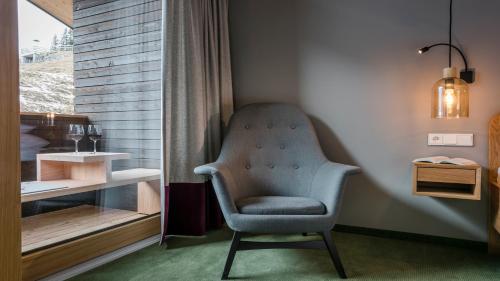 a chair sitting in a corner of a room at Hotel Stäfeli in Lech am Arlberg