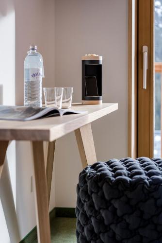 a table with a bottle of water and glasses on it at Hotel Stäfeli in Lech am Arlberg