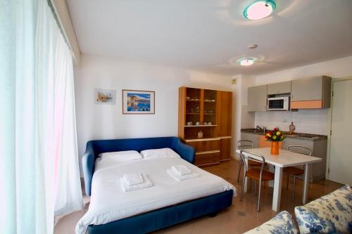 une chambre avec un lit et une table et une cuisine dans l'établissement Cosy studio vue Mer aux portes de Monaco, à Beausoleil
