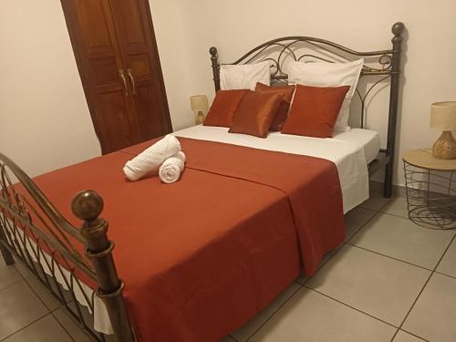 a bed with orange and white sheets and pillows at Maïlly - Charmante villa T5 in Capesterre-Belle-Eau
