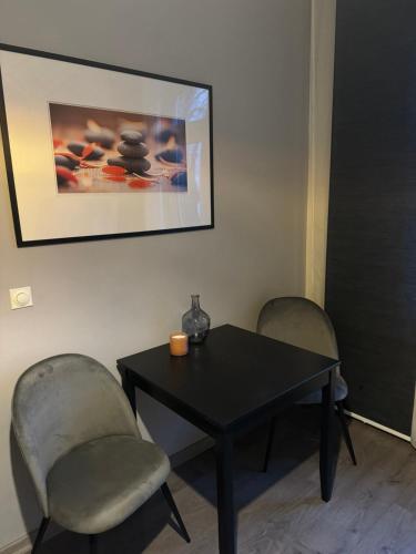a table and two chairs with a black table and a picture at Gemütliches Appartement "Emma" in Halle in Rusches Hof