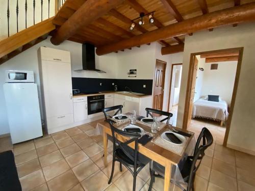 eine Küche und ein Esszimmer mit einem Tisch und Stühlen in der Unterkunft Le Mas Gabantelye in Saint-Paulet-de-Caisson