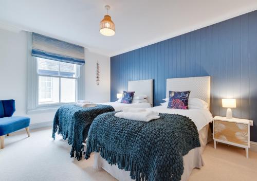 - une chambre avec 2 lits et un mur bleu dans l'établissement Pont View, à Fowey