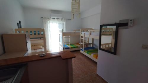 a room with several bunk beds and a mirror at Oasis Hostel in Himare