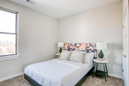 a white bedroom with a bed and a window at CozySuites Music Row Chic 1BR w free parking 57 in Nashville