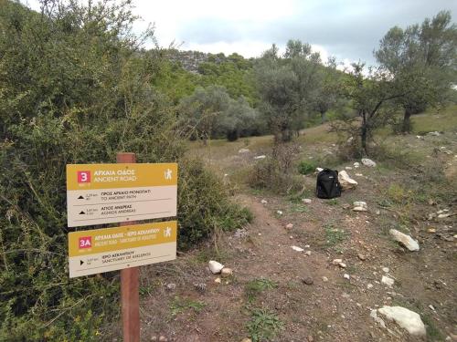 a sign on a trail with a backpack on a hill at Avaton Hotel in Ligourio