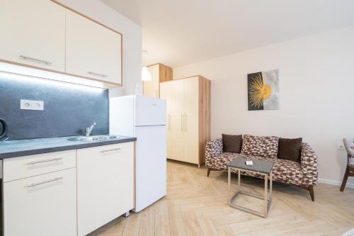 a kitchen with a white refrigerator and a couch at WOW studios for rent - bul Montevideo 25A - B in Sofia