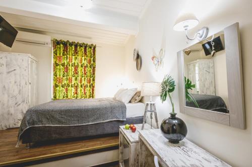 a bedroom with a bed and a mirror at Sagredo Traditional House in Nafplio