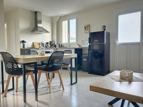 uma cozinha com uma mesa e cadeiras e um frigorífico em Le Gîte de la Forêt - Montmacq em Thourotte