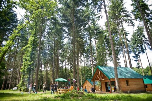 Eine Hütte im Wald mit Leuten, die um sie herum stehen. in der Unterkunft Village Huttopia Senonches - Perche in Senonches