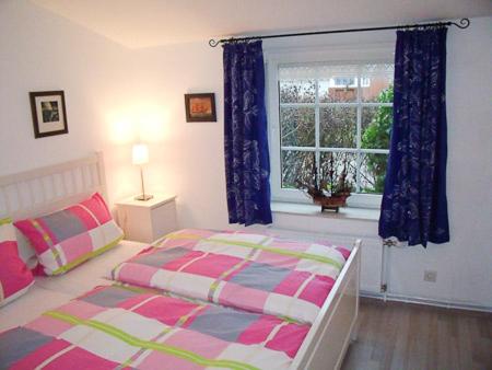 新哈林格西爾的住宿－Ferienhaus Treibholz II，一间卧室设有一张床和一个窗口