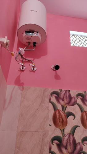 a room with a pink wall with flowers painted on it at Hari Suman Paying Guest house in Ayodhya