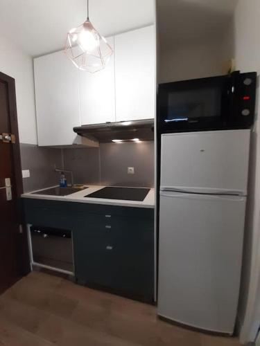 Il comprend une cuisine équipée d'un réfrigérateur noir et blanc. dans l'établissement Le Silvaplana : Apt 4 Prs, 300 m plages, parking, à Antibes