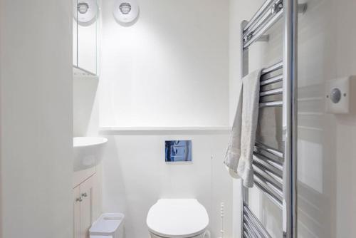 La salle de bains blanche est pourvue de toilettes et d'une serviette. dans l'établissement 8 Bredfield Street, à Woodbridge