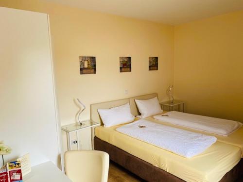 ein Schlafzimmer mit einem Bett mit zwei weißen Kissen in der Unterkunft Landhotel Bergischer Hof GmbH Marialinden in Overath