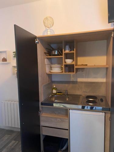 une petite cuisine avec un évier et une cuisinière dans l'établissement Studio N°2 hyper centre, à Châteaubriant