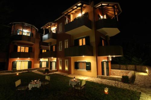 a building with tables in front of it at night at Porto Nirikos in Lefkada