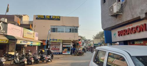 a city street with motorcycles parked in front of a building at HOTEL THE PACIFIC in Ahmedabad