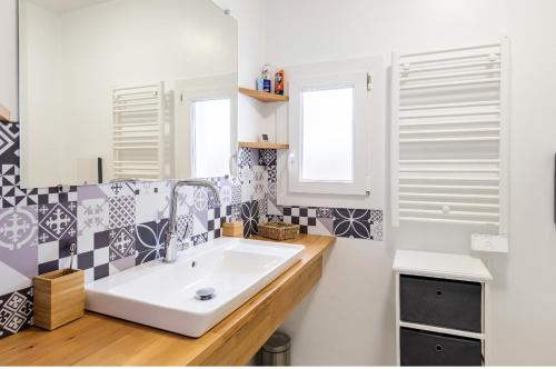 ein Bad mit einem Waschbecken und einem Spiegel in der Unterkunft Villa des Palmiers, Chambre 2, Lit double in Villeneuve-sur-Lot