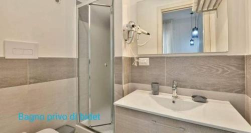 a bathroom with a sink and a shower with a mirror at B&B Iris in Santa Maria di Castellabate