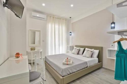 a white bedroom with a bed and a table at B&B Iris in Santa Maria di Castellabate
