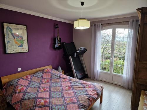 Schlafzimmer mit lila Wänden, einem Bett und einem Fenster in der Unterkunft CHAMBRE AVEC WC ET SDB PRIVATIFS in Versainville
