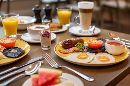 a table with plates of breakfast foods and drinks at Harbour Hotel & Spa Guildford in Guildford