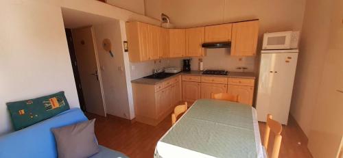 małą kuchnię ze stołem i lodówką w obiekcie TERRASSES DE LA PLAGE Joli T2 cabine proche plage Richelieu Cap d'Agde TERRASSES DE LA PLAGE w Cap d'Agde