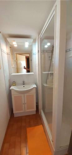 une salle de bain blanche avec un lavabo et une douche dans l'établissement TERRASSES DE LA PLAGE Joli T2 cabine proche plage Richelieu Cap d'Agde TERRASSES DE LA PLAGE, au Cap d'Agde