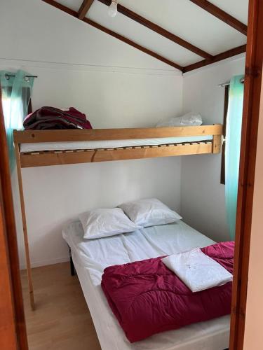 1 dormitorio con 2 literas y 1 cama roja en Chalet N13 en Saint-Julien-de-Peyrolas
