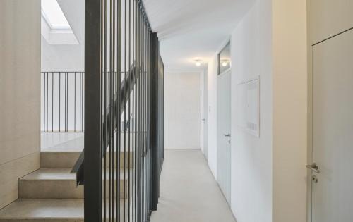 a hallway of a house with white walls and stairs at TIROLER TRIS modern villa 10 beds in Maurach
