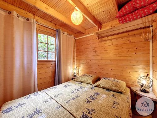 um quarto com uma cama num chalé de madeira em Scheffléra - Bungalow aux Makes - Saint-Louis em Saint-Louis